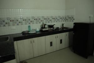 a kitchen with white cabinets and a black counter top at The aura 3bhk near Paltan Bazar in Guwahati