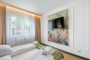 ein Schlafzimmer mit einem großen Gemälde an der Wand in der Unterkunft NORTH Apartments, Vibe Ustka in Ustka