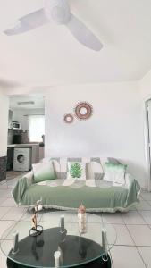 a living room with a couch and a ceiling fan at Abri Papaye in Rivière-Salée +7 photos
