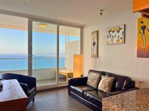 a living room with a couch and a view of the ocean at Hermoso departamento en Costa Horizonte in Concón