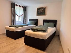 two twin beds in a room with a window at haus Plager in Landau an der Isar