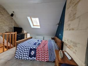 a small room with a bed in a attic at Maison de pêcheur charmante et atypique en pierre, 1 min de marche de la mer in Saint-Aubin-sur-Mer