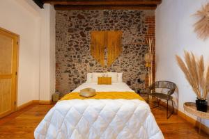a bedroom with a bed and a brick wall at DH6 Best ROOM in heart of Zocalo Cute, quite and located in Mexico City +11 photos