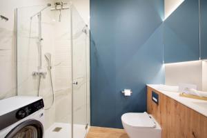 ein Badezimmer mit Toilette und Glasdusche in der Unterkunft NORTH Apartments, Vibe Ustka in Ustka + 24 Fotos
