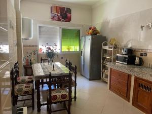 a kitchen with a table with chairs and a refrigerator at silia wifi fibre optique 200 Mé gratuit in Fès