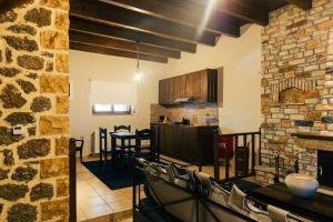 a kitchen and dining room with a stone wall at Filiantra Suites in Kato Trikala Korinthias