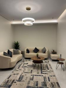 ein Wohnzimmer mit Sofa und Tisch in der Unterkunft دايموند جدة للشقق الفاخرة in Dschidda