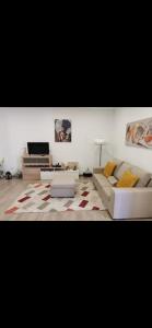 a living room with two white couches and a television at Cantinho D'Amy in Arcos de Valdevez
