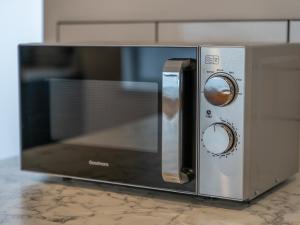 a microwave oven sitting on top of a counter at Lush apartments, Pool Table, Netflix, Parking, Long Term Discounts in Newport +70 photos