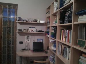 een kamer met een bureau en een boekenplank bij kondominium in San Cesareo +13 foto's