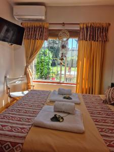 Nel's Casa Hostel A 15 minutos de Aeropuerto Ezeiza في مونتي غراندي: غرفة نوم بسرير كبير مع مناشف ونافذة