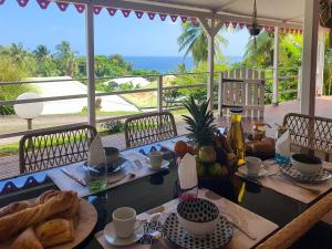 a table with food and a view of the ocean at Kaza Maléssa in Sainte-Marie