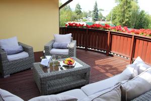 uma varanda com cadeiras e uma mesa com uma taça de fruta em Boutique Hotel Villa ZAUBER em Poprad