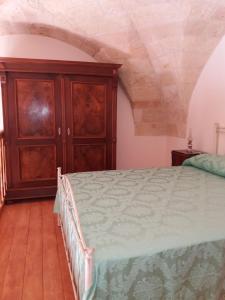 um quarto com uma cama e um armário de madeira em Loft Lo scrigno em Nardò