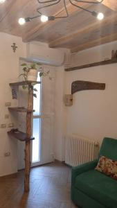 ein Wohnzimmer mit einer grünen Couch und einem Regal in der Unterkunft la meridiana lago maggiore 2 in Laveno-Mombello