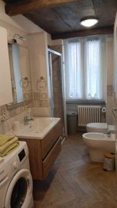 ein Badezimmer mit Waschbecken, Toilette und Waschmaschine in der Unterkunft la meridiana lago maggiore 2 in Laveno-Mombello + 15 Fotos