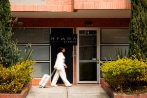 a person walking out of a building with luggage at Hemma Bogotá Chapinero Premium Suites Hotel in Bogotá