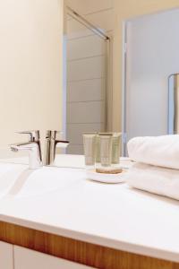 a bathroom sink with two cups and a mirror at The Babel Community - République - Joliette in Marseille