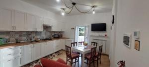 a kitchen with a table and chairs and a kitchen with white cabinets at Casa Sofia La Dimora delle Fate in Bagnoli Irpino +33 photos