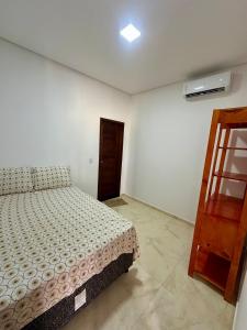 CruzにあるCasa de Praia - Preá - CEのベッドと木製のキャビネットのある寝室 +3枚の写真