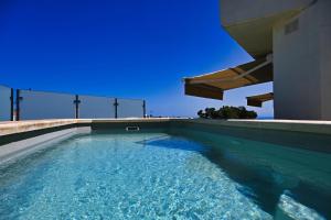 a swimming pool on the side of a house at Gozo Luxury Penthouse in Qala