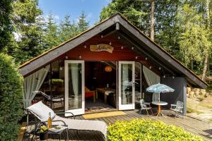 a small house with a deck and a patio at Unique forest cabin by lake near Legoland, ForestCabinDK in Ansager