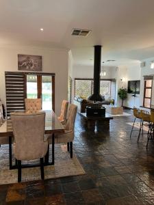 a living room with a dining table and a fireplace at Forest Crescent Villa - Pecanwood Golf Estate, Hartbeespoort in Hartbeespoort