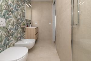a bathroom with a toilet and a sink and a shower at Riviera Suite in Santa Marinella +23 photos