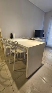 - une table et des chaises blanches dans la chambre dans l'établissement Alquiler Temporario Rosario 25, à Rosario 2 autres photos