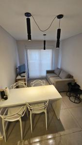 un salon avec un canapé, une table et des chaises dans l'établissement Alquiler Temporario Rosario 25, à Rosario