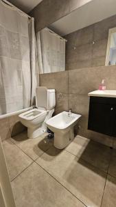 La salle de bains est pourvue de toilettes, d'un bidet et d'un lavabo. dans l'établissement Alquiler Temporario Rosario 25, à Rosario