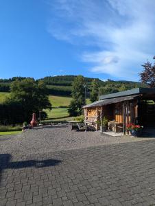 a pavilion with a building with a table and benches at Ferienwohnung Barbara in Kirchhundem +17 photos