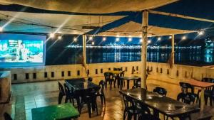 a restaurant with tables and chairs and a large screen at Casa del Jaibo in Heroica Alvarado