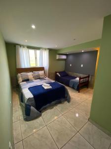 a bedroom with two beds and a couch in it at Espaço dos Lobato in Miguel Pereira