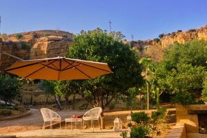 a table and two chairs and an umbrella at Villa Cavetta in Agrigento