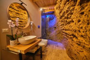 a bathroom with a sink and a stone wall at Villa Cavetta in Agrigento +69 photos