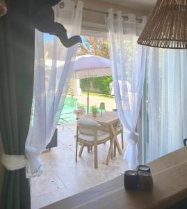 a room with a table and a chair and a window at La Petite Escale in Lunel