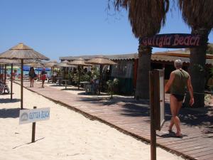 a man walking on a beach with a sign on it at Casa alla Guitgia 2 in Lampedusa +18 photos