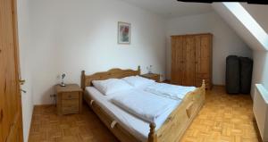 a bedroom with a wooden bed with white sheets at Bennis Rodelhaus in Oberhof
