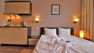 una camera da letto con un grande letto bianco con due cuscini di SPA Suite a Bansko