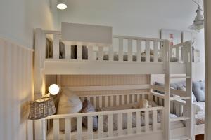 ヴァンガーオーゲにあるBootshaus I Zuhause im Bootshausの子供部屋の白い二段ベッド1台