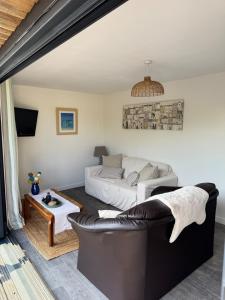 a living room with a couch and a bed at The Beach Hut in Perranporth