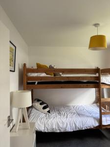 a bedroom with two bunk beds and a lamp at The Beach Hut in Perranporth +6 photos