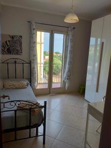 a bedroom with a bed and a view of a balcony at Etna House in Santa Maria di Licodia