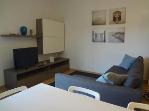 a living room with a blue couch and a tv at La Pineta Apartment in Viareggio