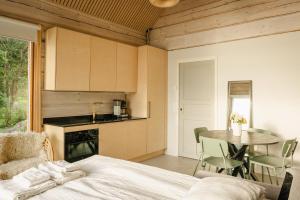 a bedroom with a bed and a table and a kitchen at Lakefront log suite in Lempäälä +21 photos