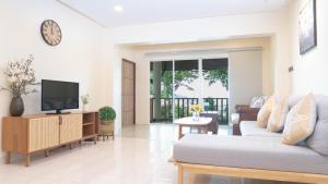 a living room with a couch and a tv at Jaokhun Hilltop Patong, Phuket in Patong Beach