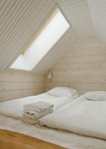 a bedroom with two white beds in a attic at Lakefront log suite in Lempäälä