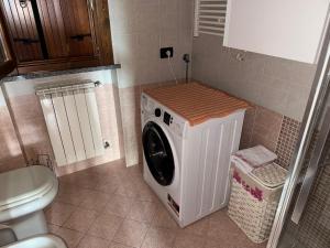 a washer and dryer in a bathroom with a toilet at La Cà dol Carlì in Clusone