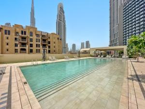 een groot zwembad in een stad met hoge gebouwen bij Luxury 2BR with Burj Khalifa Views l Near Dubai Mall in Dubai